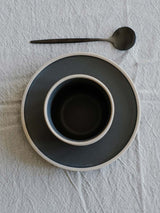 bruin mok met onderzetter en zwarte lepel