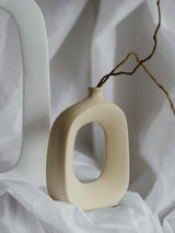 kleine beige vaas mit opening in het midden